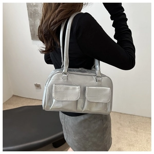 Detail der silbernen Metallic-Achseltasche mit Vordertaschen und Ledertextur
