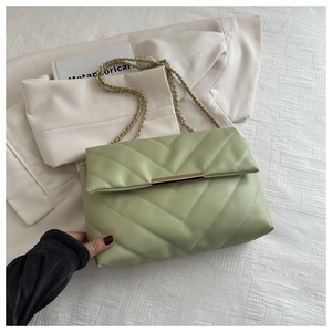 Dettaglio macro di borsa in pelle trapuntata verde menta con catena e finiture oro