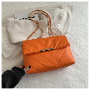 Dettaglio borsa in pelle trapuntata arancione con elegante catena dorata e finiture