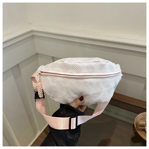 Detalle de la textura tejida crema y correa rosa ajustable de una riñonera con estilo