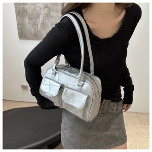 Detail der silbernen Metallic-Schultertasche mit zwei Vordertaschen und feiner Textur