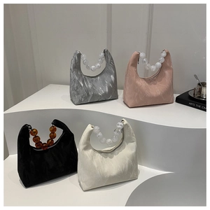 Detailed view of crescent handbags with crinkled texture and stylish beaded handles