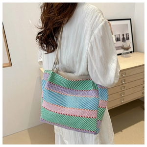 Detailed view of colorful striped woven tote bag with premium cream leather shoulder strap