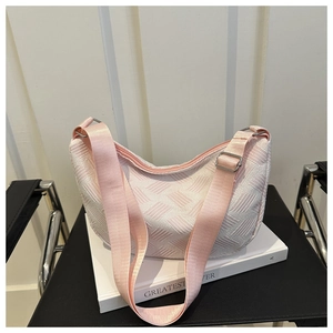 Detail of pink and white geometric woven fabric texture on a hobo dumpling bag