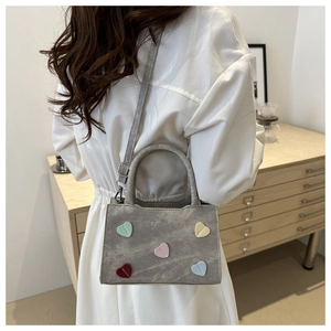Detail of grey felt tote bag with colorful heart patches and fashion embossed logo