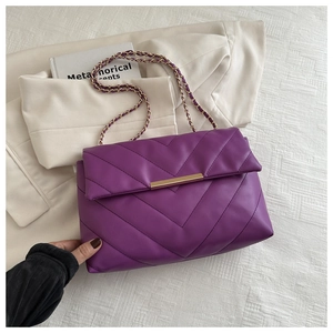 Dettaglio della borsa trapuntata viola con catena, cuciture a V e fibbia dorata