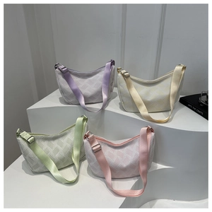 Detailed view of textured crescent shoulder bags in lilac, beige, mint and pink colors