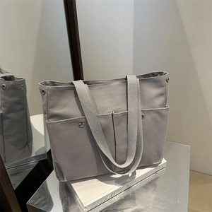 Grand sac cabas gris en toile avec poches avant et rivets argentés pour le quotidien