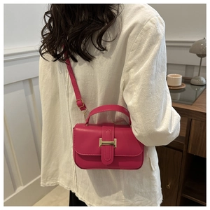 Dettaglio di una mini borsa quadrata rosa acceso con elegante chiusura in metallo oro
