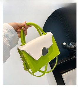 Detail of green and beige PU leather handbag with black stone buckle and stitching