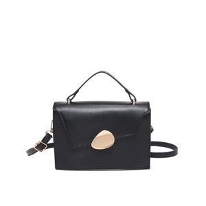 Minimalist black top handle crossbody bag with matte finish and gold oval metal buckle