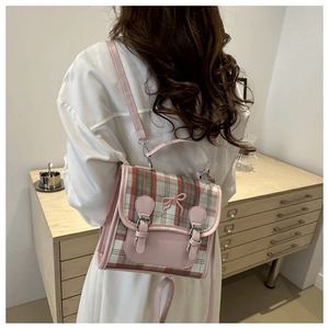 Detail of pink and green plaid mini backpack with bow decoration on model back