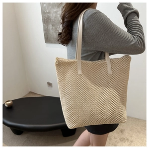 Dettaglio della trama a maglia cava intrecciata su questa borsa tote estiva beige
