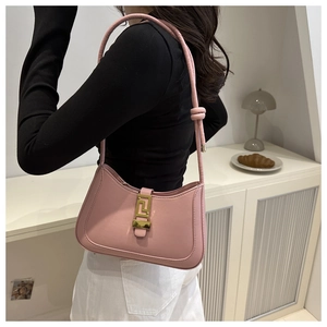 Sac porté épaule en cuir rose avec boucle dorée et détail de nœud élégant sur la bandoulière