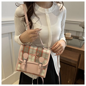 Japanese style pink and green plaid crossbody bag with bow detail on a model