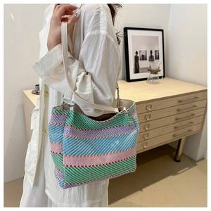 Detail of colorful woven shoulder bag with striped cotton rope and beige leather strap