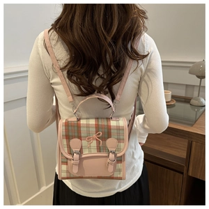 Detail of pink plaid tweed backpack with a 3D bow and synthetic leather trim