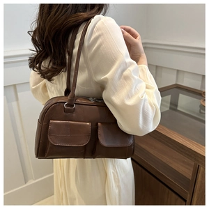 Detail der dunkelbraunen Retro-Schultertasche mit vorderen Klappentaschen und Ledertextur