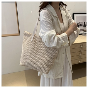 Dettaglio della borsa tote in maglia beige con trama fine e tracolla in pelle
