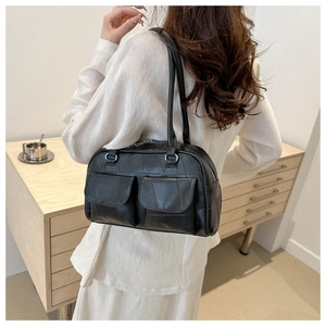 Details einer schwarzen Vintage Leder-Schultertasche mit zwei großen Vordertaschen und Trägern