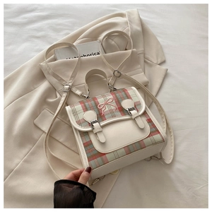 Detail of tartan plaid canvas and beige faux leather backpack with pink bow embroidery