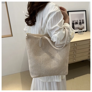 Dettaglio della borsa tote intrecciata beige con trama a rete e manici in ecopelle