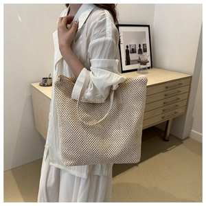 Dettaglio di una grande borsa tote intrecciata con spalline sottili per le vacanze estive