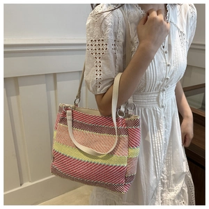 Detailed close-up of rainbow striped woven tote bag with premium leather straps
