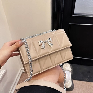 Sac bandoulière beige matelassé avec nœud argenté et bandoulière en chaîne
