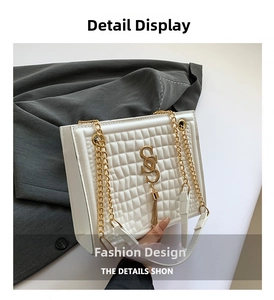 Detail der weißen Stepptasche mit goldenem SS-Logo und elegantem Quastenanhänger