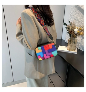 Detail of colorful geometric patchwork crossbody bag with wide ethnic pattern strap