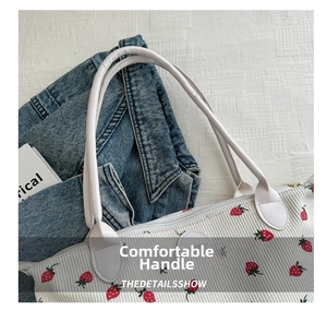 Close-up of comfortable white leather handles and red strawberry corduroy tote bag details