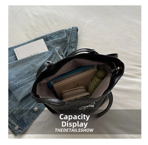 Top view of spacious black tote bag showing storage for books, phone and umbrella
