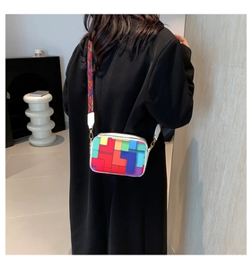 Detail of colorful geometric patchwork crossbody bag with woven wide shoulder strap