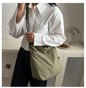 Vue détaillée du sac seau vert armée avec bandoulière tissée noire et blanche stylée