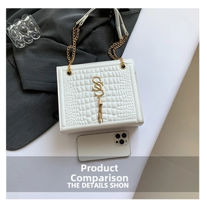 Details der weißen Krokoprägung-Tasche mit goldener Quaste und Kettenriemen-Akzenten