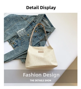 Detail of woven cream tote bag texture with brown logo patch and slim leather strap