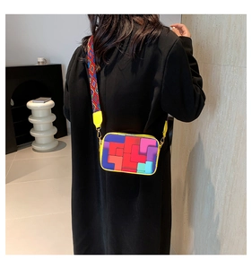 Detail of a colorful geometric patchwork crossbody bag with wide ethnic shoulder strap