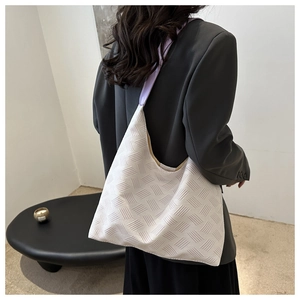 Détail du sac à bandoulière en tissu blanc texturé avec une sangle en cuir violet