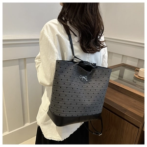 Close-up of heart pattern canvas backpack with a metallic bow and leather base detail