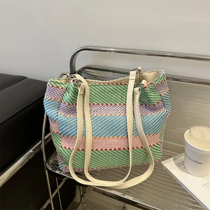 Colorful striped woven tote bag with cream leather straps on a display rack