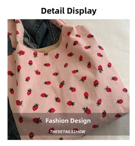 Close-up of pink corduroy fabric with strawberry print on a spacious tote bag