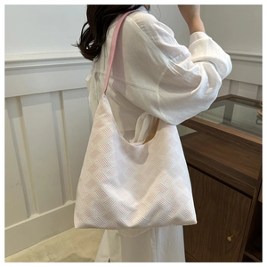 Close-up of pink and white textured bubble tote bag worn on shoulder for style display