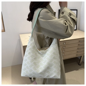 Detail of woven texture on minimalist tote bag with light green shoulder strap