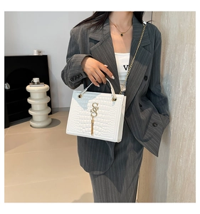 Détail du sac bandoulière blanc motif crocodile avec chaîne dorée et logo SS métal