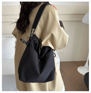 Détail du sac cabas en nylon noir avec bandoulières en corde tressée noire et blanche