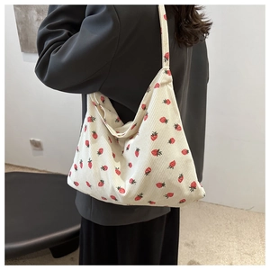 Détail d'un grand sac cabas en velours côtelé blanc cassé avec motifs fraises rouges