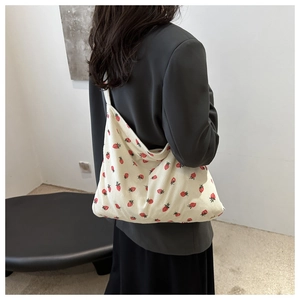 Détail du sac cabas en velours côtelé blanc cassé avec imprimé fraise sur modèle