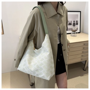 Fashionable hobo shoulder bag with textured white fabric and light green leather strap