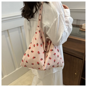 Détail du sac fourre-tout en velours côtelé rose avec imprimé fraise et bandoulière